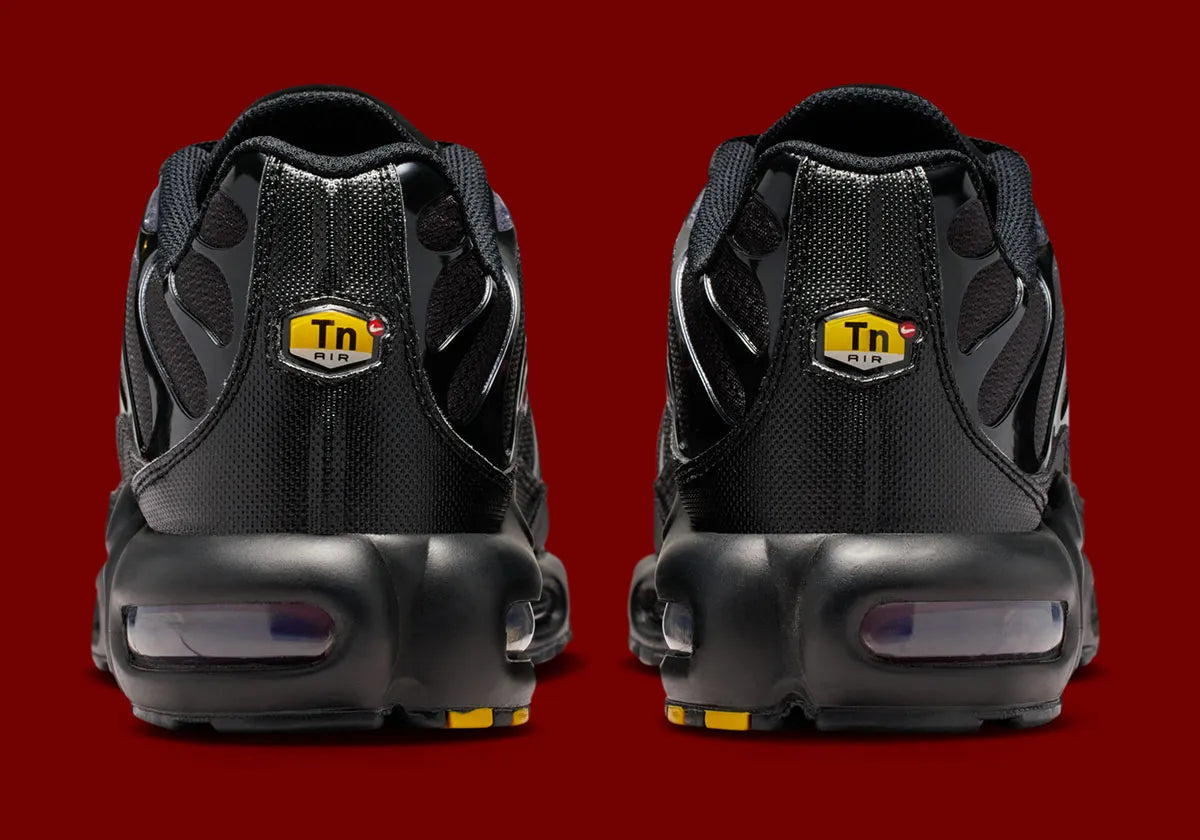 Nike Air Max Plus Black Pencil Point Team Crimson noire avec détails rouges Team Crimson, renforts ondulés et unités Air visibles.
