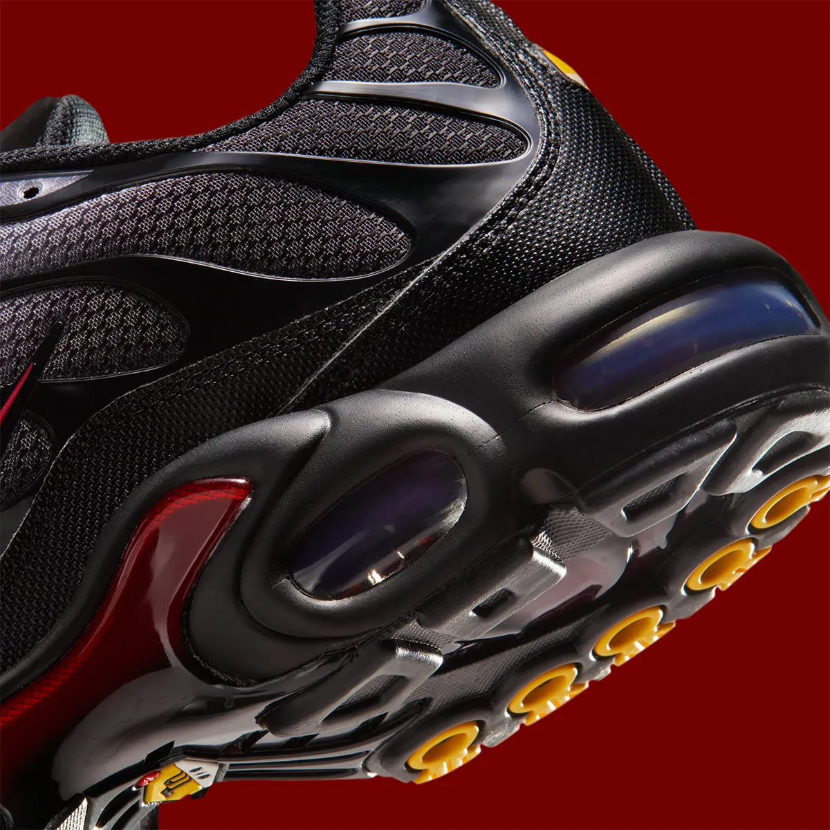 Nike Air Max Plus Black Pencil Point Team Crimson noire avec détails rouges Team Crimson, renforts ondulés et unités Air visibles.