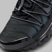 Sneakers Nike Air Max Plus Utility noires avec détails Metallic Platinum en mesh technique et matières renforcées avec amorti Tuned Air visible
