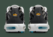 Nike Air Max Plus Iridescent noire avec tige aux reflets violet, bleu, vert et rose, cage noire et unités Air visibles vue de derrière. 