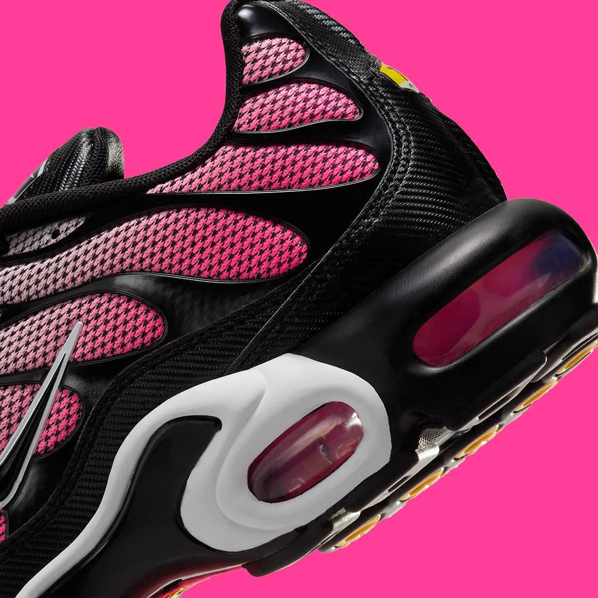 Image de la Nike Air Max Plus “All Day”, sneaker mesh dégradé rose/rouge « Sunset Pulse » avec cages TPU noires ondulées, bulles Tuned Air visibles, silhouette TN modernisée. Vue zoomer arrière 