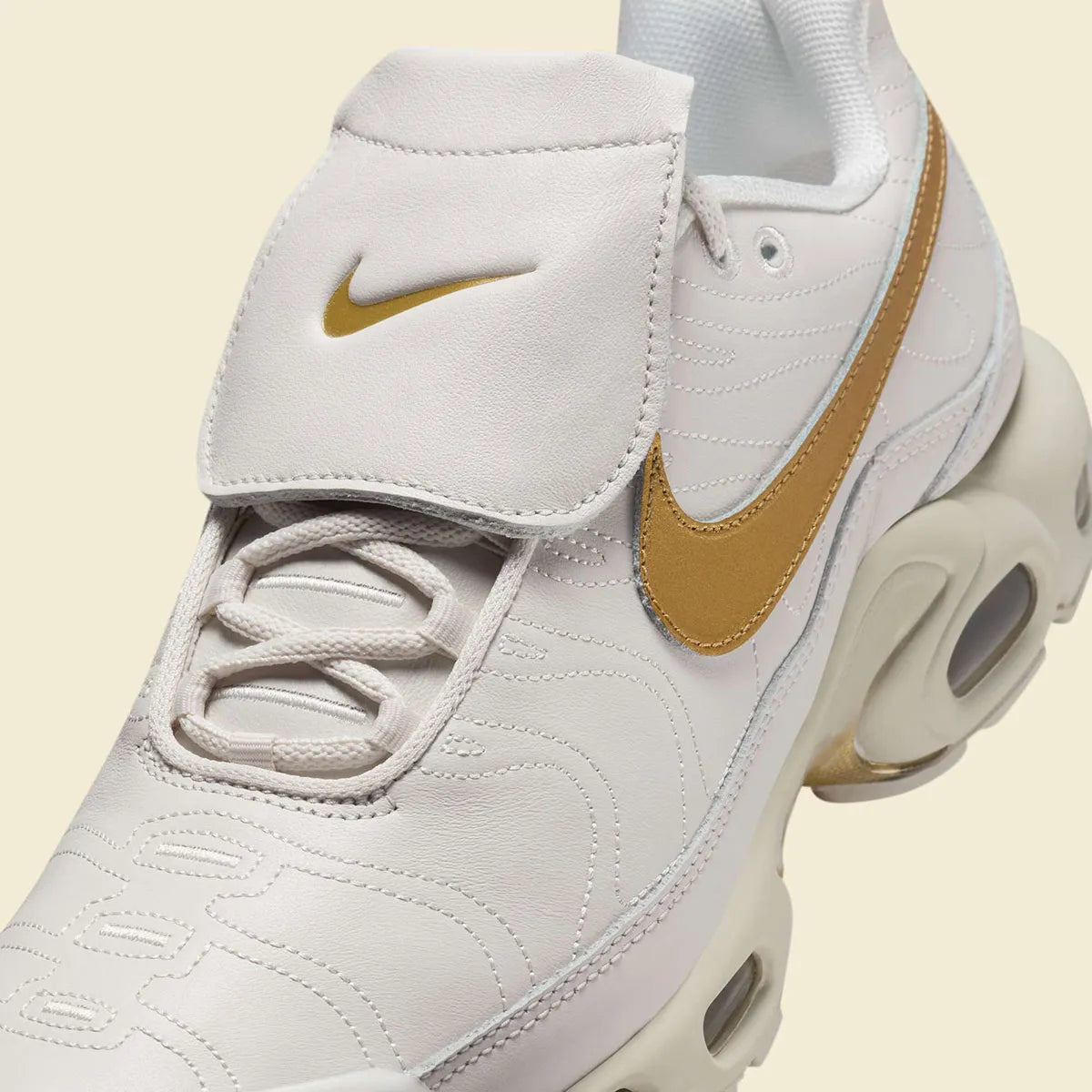 Nike Air Max Plus Tiempo Metallic Gold, sneaker Phantom et dorée en cuir matelassé avec languette football Tiempo et semelle Tuned Air.