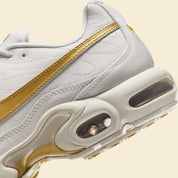 Nike Air Max Plus Tiempo Metallic Gold, sneaker Phantom et dorée en cuir matelassé avec languette football Tiempo et semelle Tuned Air.