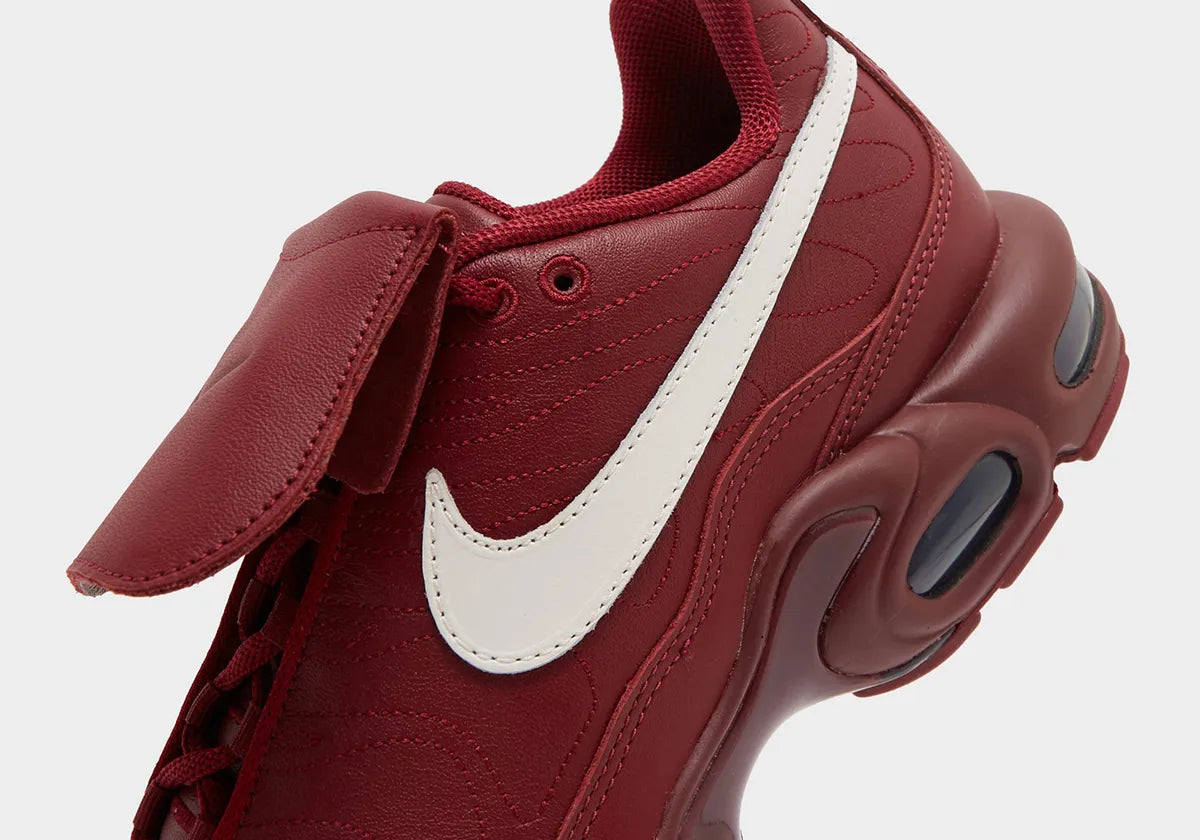 Nike Air Max Plus Tiempo Team Red en cuir rouge avec Swoosh Sail, languette rabattable inspirée de la Tiempo et unités Tuned Air visibles.
