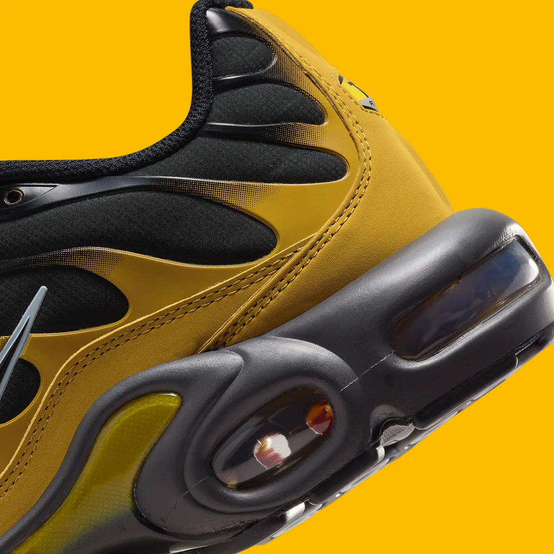 Nike Air Max Plus Bronzine beige et taupe avec tige en mesh, détails noirs, renforts ondulés et unités Air visibles.