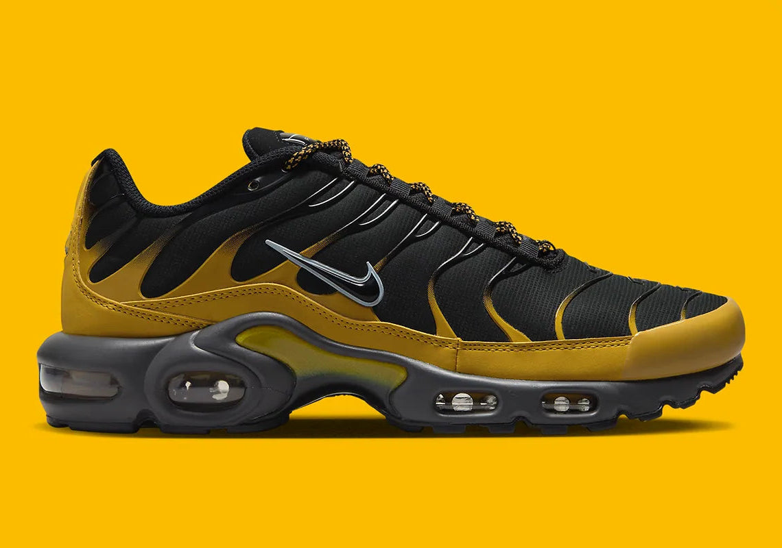 Nike Air Max Plus Bronzine beige et taupe avec tige en mesh, détails noirs, renforts ondulés et unités Air visibles.F