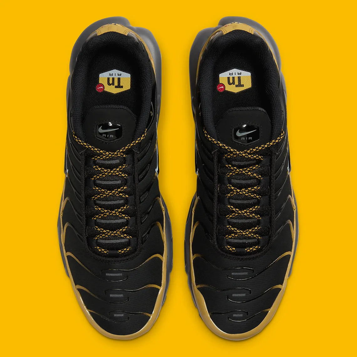 Nike Air Max Plus Bronzine beige et taupe avec tige en mesh, détails noirs, renforts ondulés et unités Air visibles.
