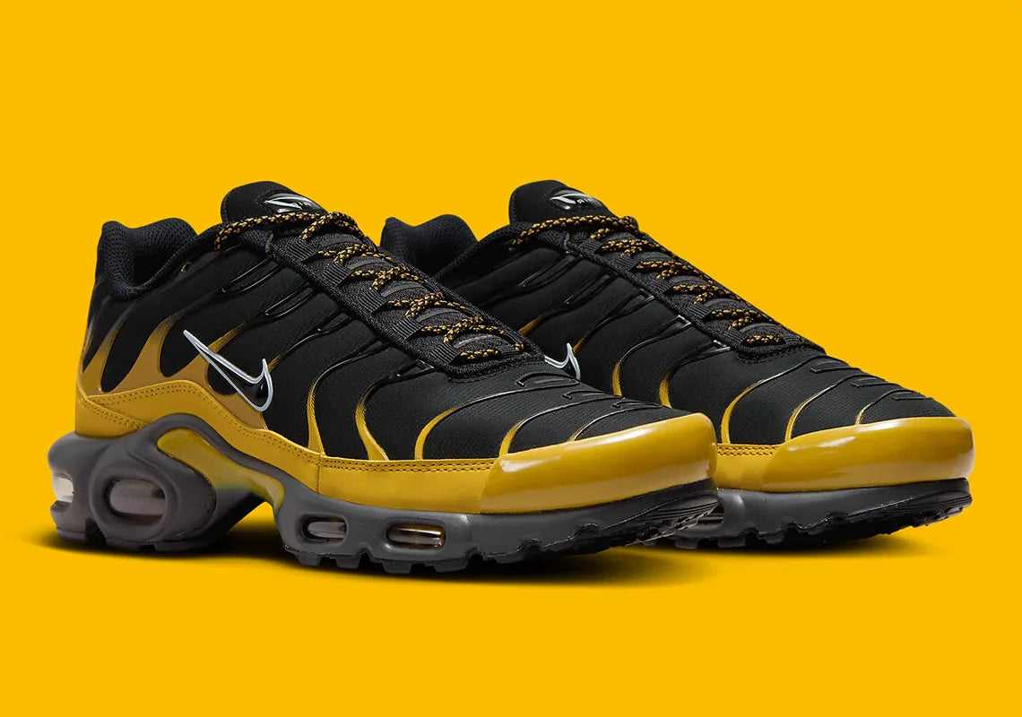 Nike Air Max Plus Bronzine beige et taupe avec tige en mesh, détails noirs, renforts ondulés et unités Air visibles.
