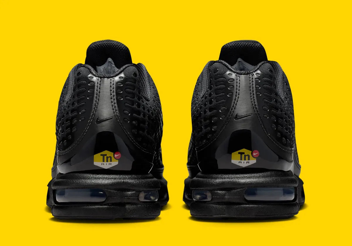 Nike Air Max Plus 7 Black noire et anthracite avec tige en mesh, renforts ondulés et unités Nike Air visibles vue de derrière. 
