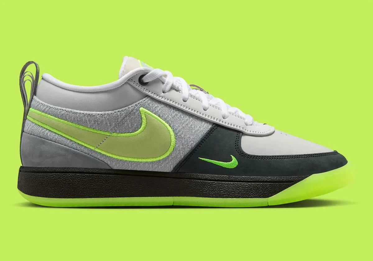Nike Book 1 Neon 95 à silhouette basse, avec tige multicouche grise et sombre, accents vert fluorescent, amorti Zoom Air et semelle extérieure en caoutchouc adhérente.