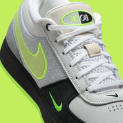 Nike Book 1 Neon 95 à silhouette basse, avec tige multicouche grise et sombre, accents vert fluorescent, amorti Zoom Air et semelle extérieure en caoutchouc adhérente.