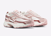 Nike Initiator Red Sepia Echo Pink IB4339-002 avec tige crème et beige, accents rose et brun et silhouette rétro-running multicouche vue de 3/4 face. 