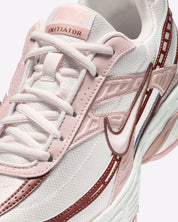 Vue zoomée sur les détails latéraux de la Nike Initiator Red Sepia Echo Pink IB4339-002 avec tige crème et beige, accents rose et brun et silhouette rétro-running multicouche.
