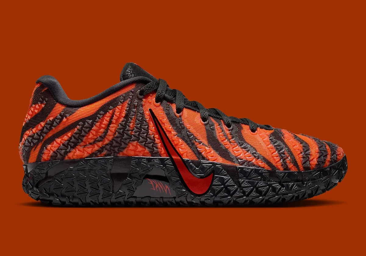 Nike Ja 3 Animal Pack Tiger avec tige textile aux tons chauds et motifs rayés, renforts structurés, amorti réactif et semelle en caoutchouc adhérente.