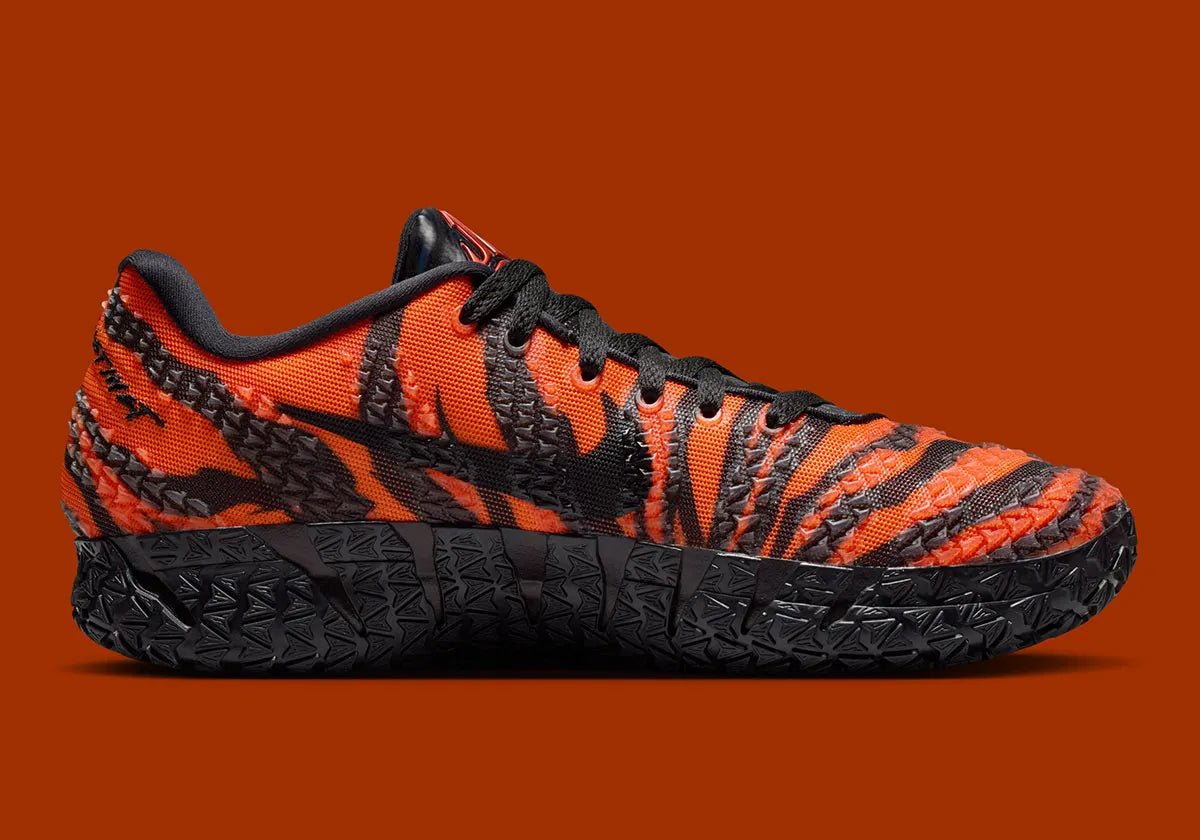 Nike Ja 3 Animal Pack Tiger avec tige textile aux tons chauds et motifs rayés, renforts structurés, amorti réactif et semelle en caoutchouc adhérente.