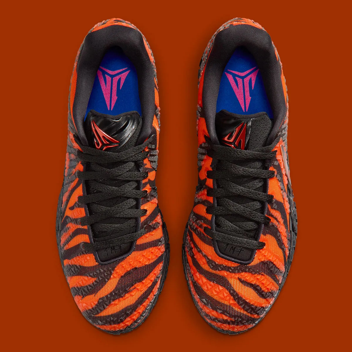 Nike Ja 3 Animal Pack Tiger avec tige textile aux tons chauds et motifs rayés, renforts structurés, amorti réactif et semelle en caoutchouc adhérente.