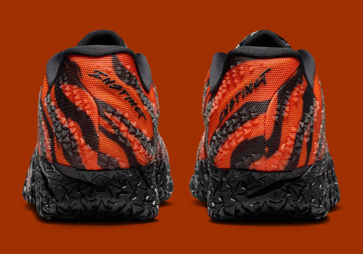 Nike Ja 3 Animal Pack Tiger avec tige textile aux tons chauds et motifs rayés, renforts structurés, amorti réactif et semelle en caoutchouc adhérente.