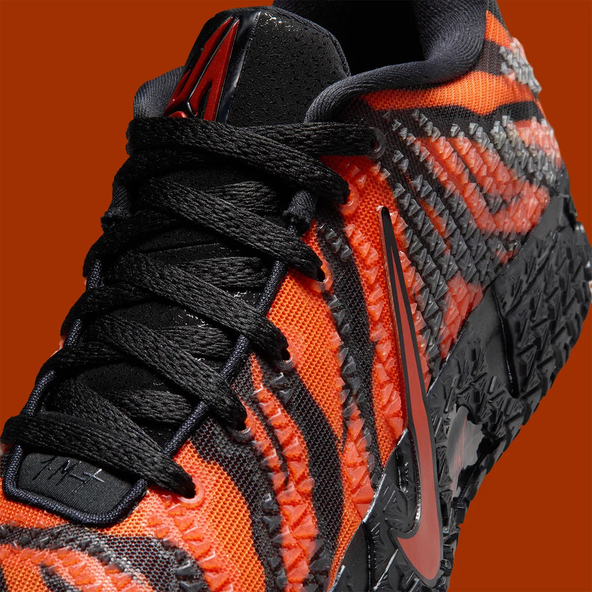 Nike Ja 3 Animal Pack Tiger avec tige textile aux tons chauds et motifs rayés, renforts structurés, amorti réactif et semelle en caoutchouc adhérente.