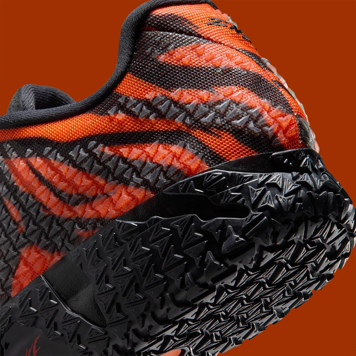 Nike Ja 3 Animal Pack Tiger avec tige textile aux tons chauds et motifs rayés, renforts structurés, amorti réactif et semelle en caoutchouc adhérente.