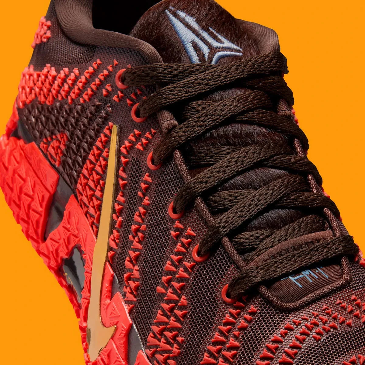Vue zoomée sur les détails de la languette de la sneakers Nike Ja 3 Year Of The Horse rouges et dorées en mesh technique avec amorti Zoom Air et design symbolique premium