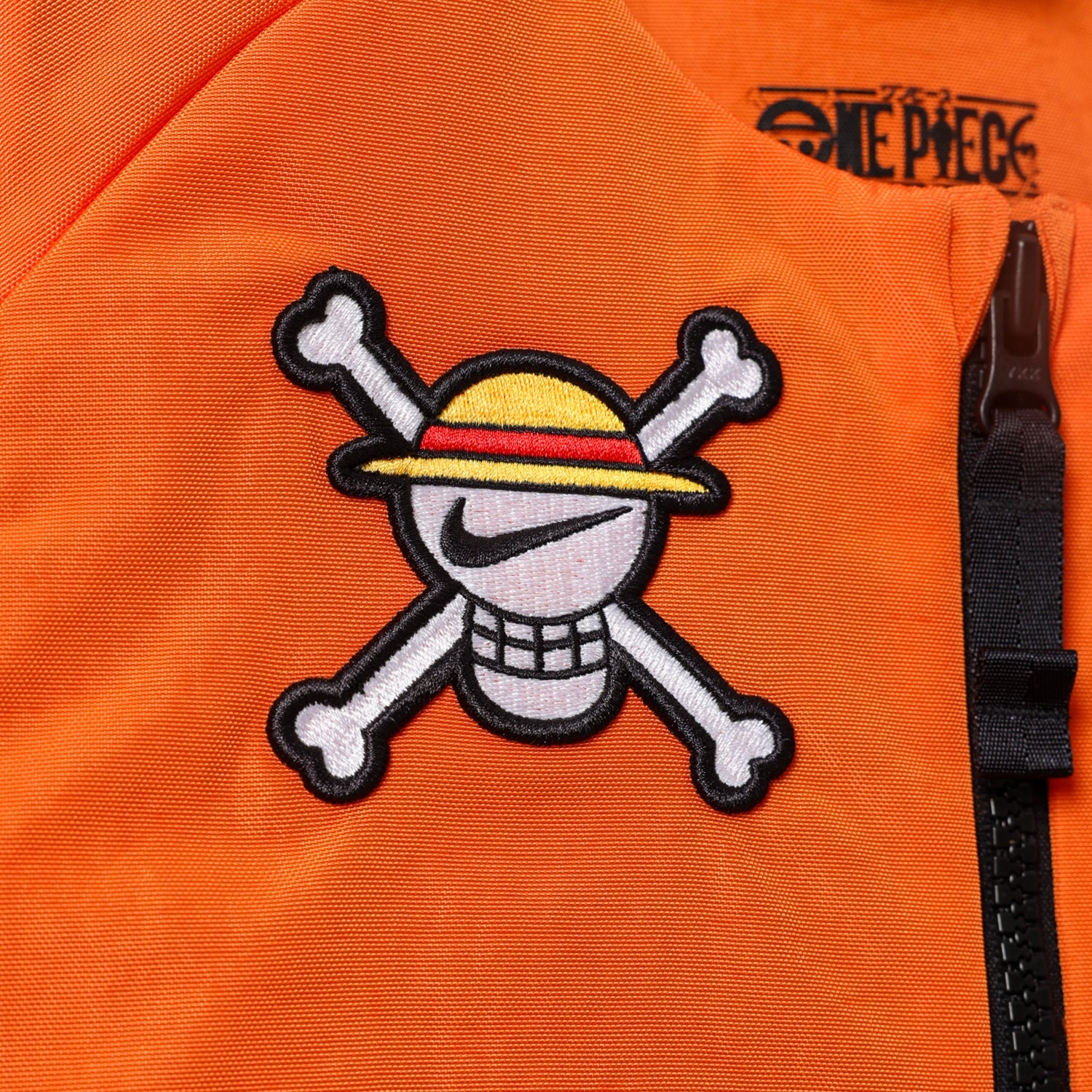 Nike x One Piece Vest Safety Orange, gilet Nike sans manches orange avec détails graphiques One Piece et branding de la collaboration.