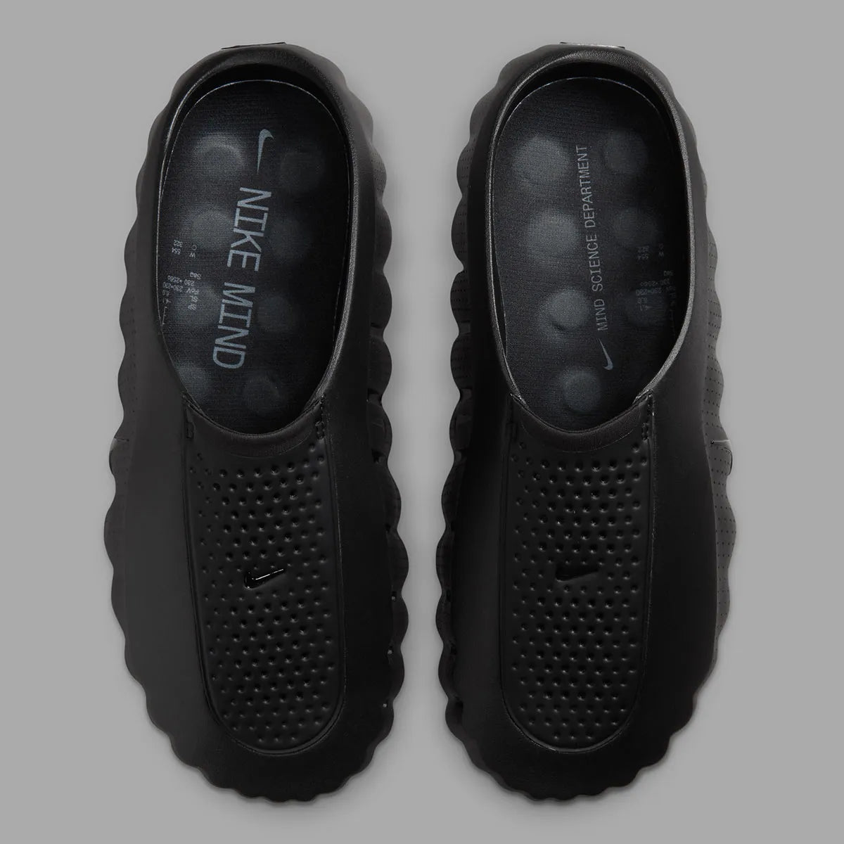 Nike Mind 001 Slide Triple Black avec construction mule entièrement noire, empeigne technique respirante et semelle sensorielle avec amorti en mousse souple.