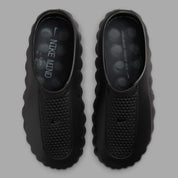 Nike Mind 001 Slide Triple Black avec construction mule entièrement noire, empeigne technique respirante et semelle sensorielle avec amorti en mousse souple.