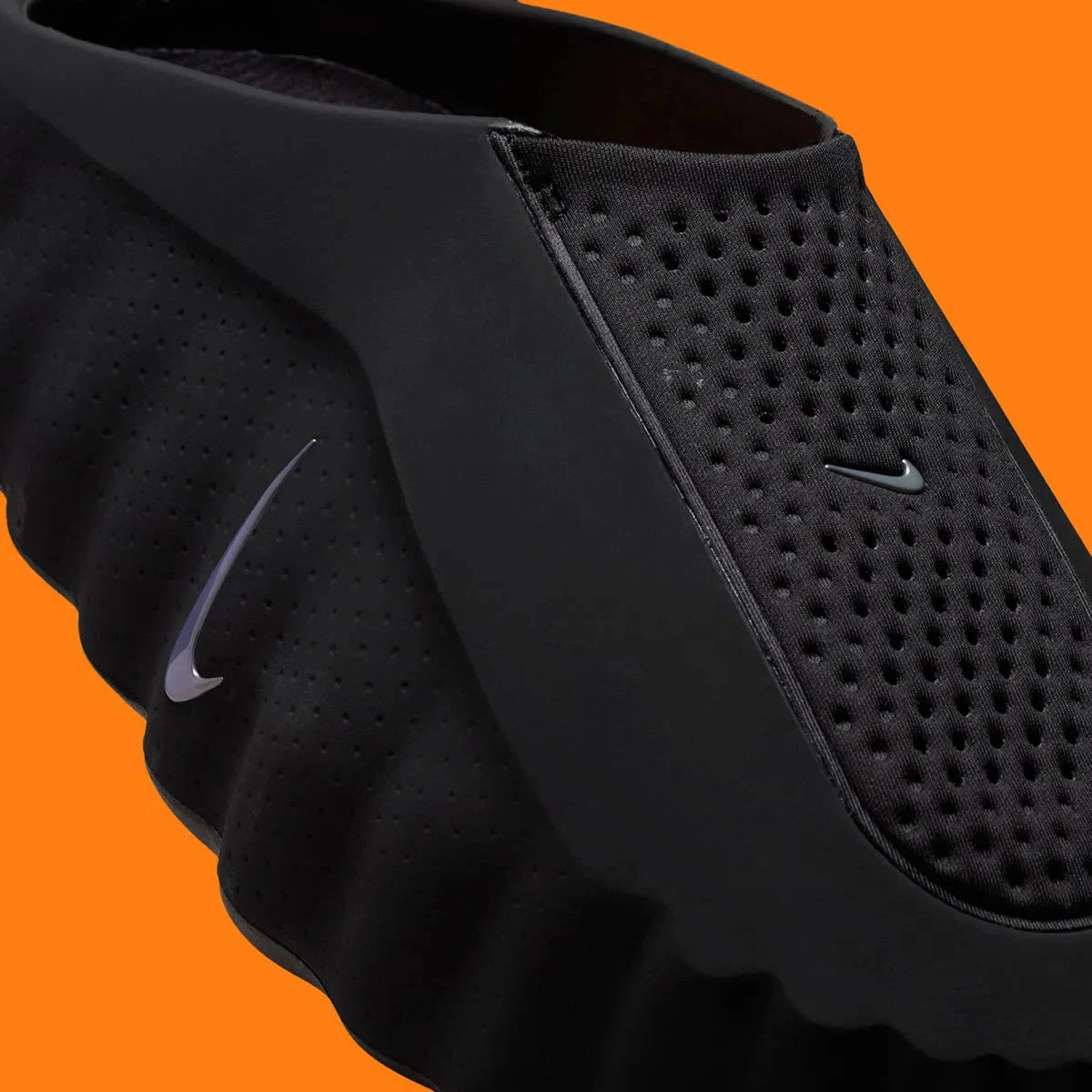 Slides Nike Mind 001 Black Chrome noires et chromées en mousse technique avec nœuds sensoriels sous la semelle et design futuriste, vue zoomée sur l'avant la paire. 