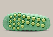 Nike Mind 001 Slide Cucumber Calm HQ4307-302 avec empeigne moulée vert pastel, détails noirs, accents Barely Volt et semelle sensorielle à 22 points de pression articulés.