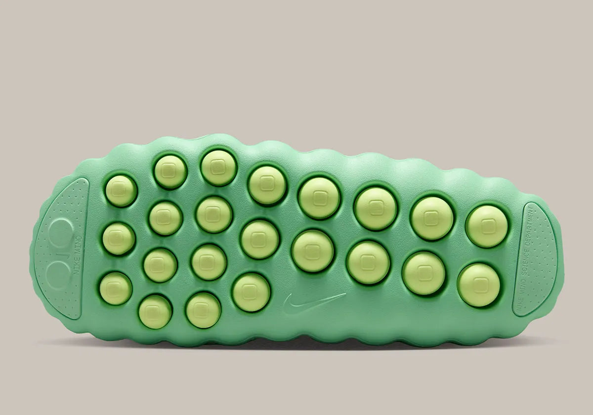 Nike Mind 001 Slide Cucumber Calm HQ4307-302 avec empeigne moulée vert pastel, détails noirs, accents Barely Volt et semelle sensorielle à 22 points de pression articulés.