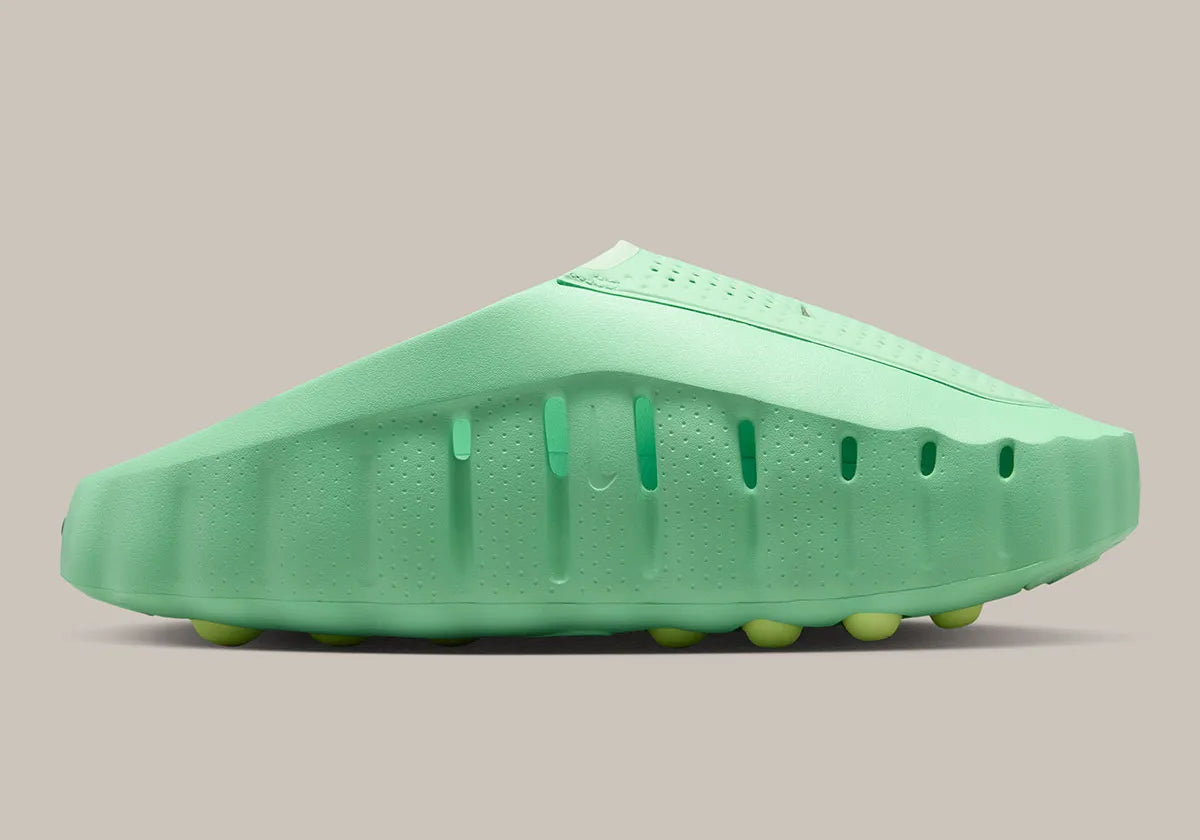 Nike Mind 001 Slide Cucumber Calm HQ4307-302 avec empeigne moulée vert pastel, détails noirs, accents Barely Volt et semelle sensorielle à 22 points de pression articulés.