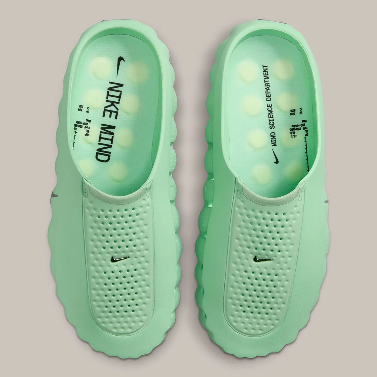 Nike Mind 001 Slide Cucumber Calm HQ4307-302 avec empeigne moulée vert pastel, détails noirs, accents Barely Volt et semelle sensorielle à 22 points de pression articulés.
