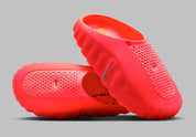 Nike Mind 001 Slide Solar Red avec construction mule rouge vif, détails Hyper Crimson, Black et Chrome, et semelle sensorielle intégrant 22 éléments en mousse indépendants.
