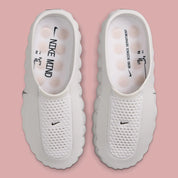 Nike Mind 001 Slide Summit White avec empeigne en maille perforée claire, construction mule et semelle sensorielle à 22 points de pression articulés.