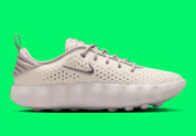 Nike Mind 002 Phantom College Grey avec tige en textile technique clair, détails gris, construction enveloppante et semelle sensorielle avec amorti en mousse souple.