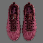 Nike Mind 002 Pink Smoke Mystic Dates avec tige en textile technique rose fumé, détails aux nuances terreuses et semelle moderne offrant confort et adhérence.