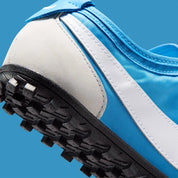 Vue zoomée sur les détails arrières de la Nike Moon Shoe OG SP Italy Blue Neutral Grey, sneaker Nike rétro-running bleue et grise inspirée des années 1970 avec Swoosh et semelle Waffle.