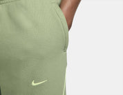 Nike x NOCTA Fleece CS Sweatpant Oil Green/Light Liquid Lime, pantalon fleece vert avec coupe ample, poches zippées et détails réfléchissants NOCTA.