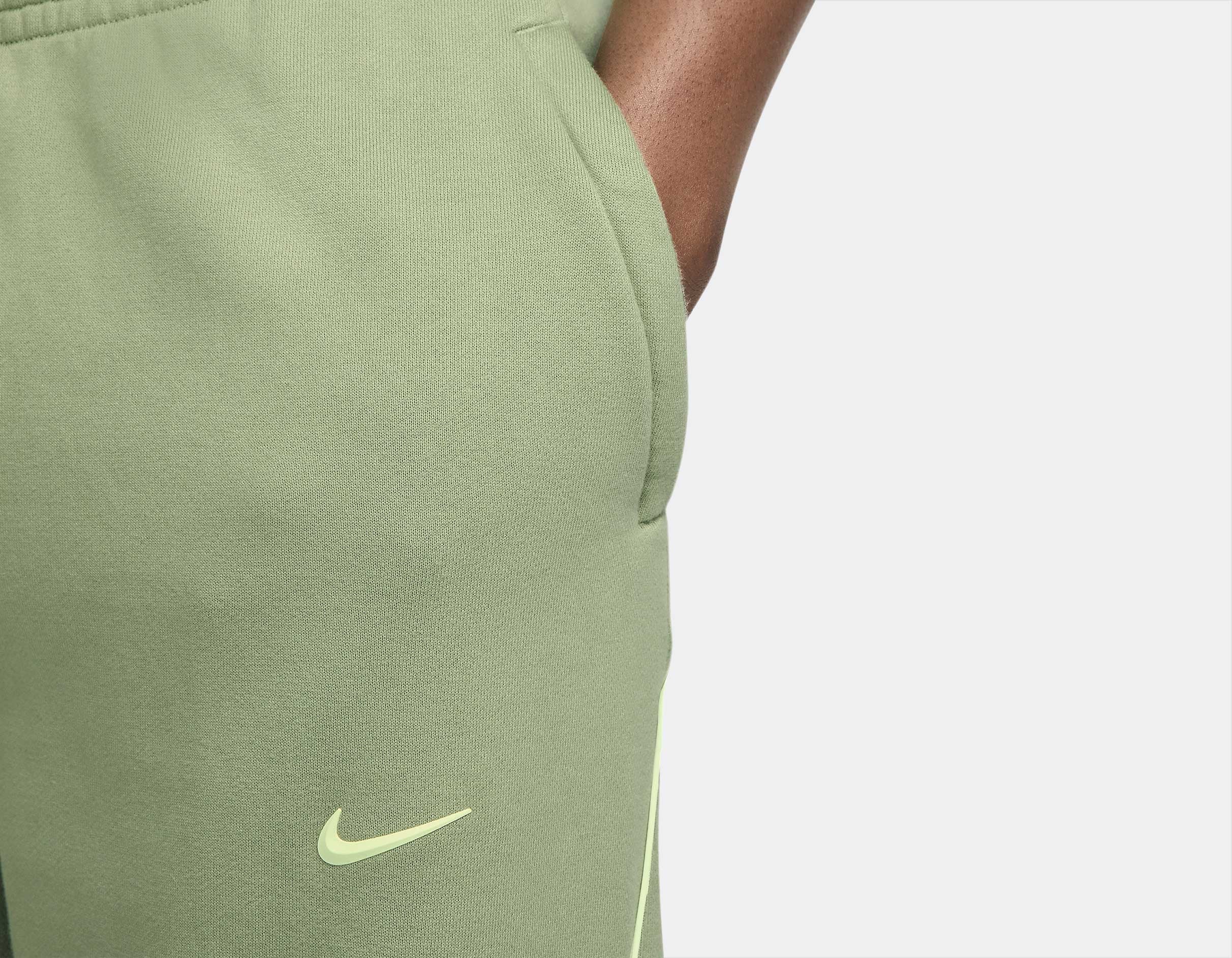 Nike x NOCTA Fleece CS Sweatpant Oil Green/Light Liquid Lime, pantalon fleece vert avec coupe ample, poches zippées et détails réfléchissants NOCTA.