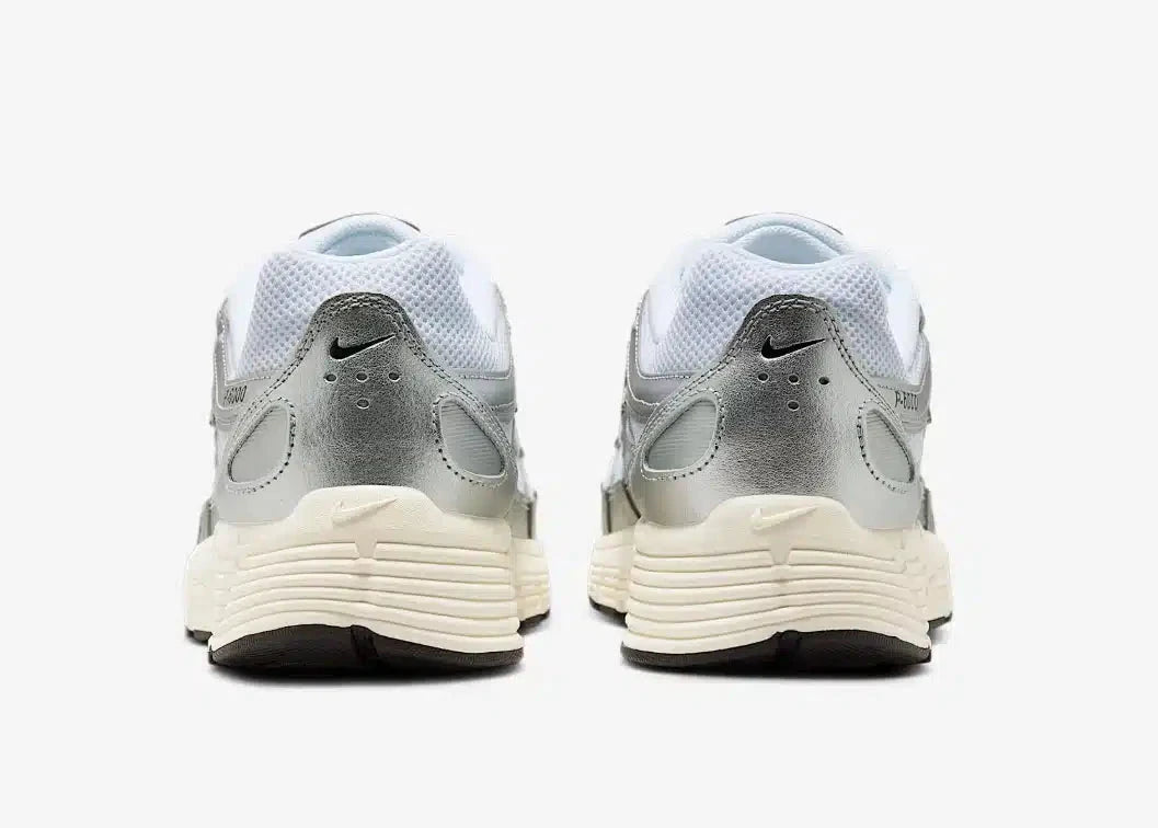 La Nike P-6000 White Metallic Silver Flat Silver Black en mesh blanc et cuir synthétique argenté avec semelle caoutchouc, design rétro-running.