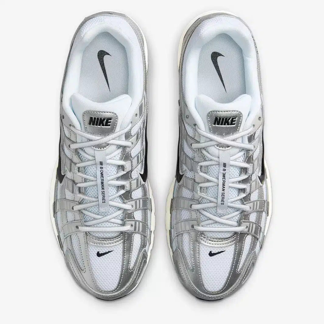La Nike P-6000 White Metallic Silver Flat Silver Black en mesh blanc et cuir synthétique argenté avec semelle caoutchouc, design rétro-running.