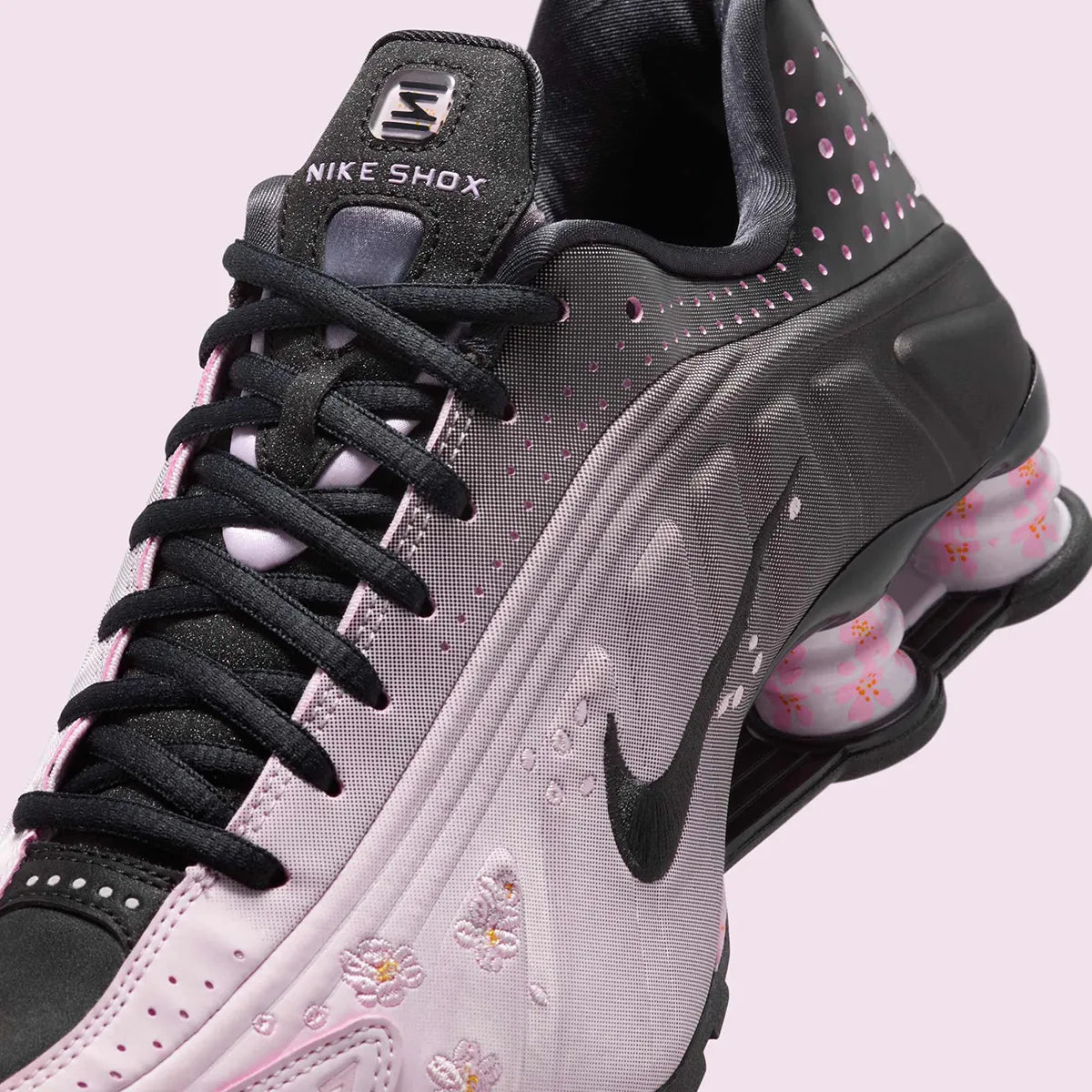 Nike Shox R4 Sakura avec finition rose Sakura et amorti Nike Shox au talon.