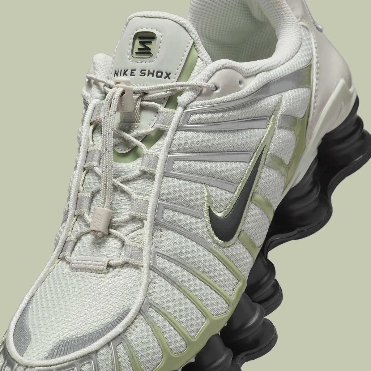 Nike Shox TL Olive Aura, sneaker Light Bone et vert olive avec tige en mesh, détails argentés et colonnes Nike Shox sur toute la semelle.