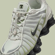 Nike Shox TL Olive Aura, sneaker Light Bone et vert olive avec tige en mesh, détails argentés et colonnes Nike Shox sur toute la semelle.