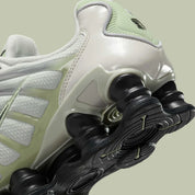 Nike Shox TL Olive Aura, sneaker Light Bone et vert olive avec tige en mesh, détails argentés et colonnes Nike Shox sur toute la semelle.