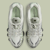 Nike Shox TL Olive Aura, sneaker Light Bone et vert olive avec tige en mesh, détails argentés et colonnes Nike Shox sur toute la semelle.
