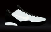 Image de la Nike Kobe 6 Black Mamba Collection Fade To Black, sneaker de basketball gris anthracite texturée en écaille de serpent, semelle Zoom Air et finitions dorées. Vue de profil dans le noir pour voir le glow de la paire.
