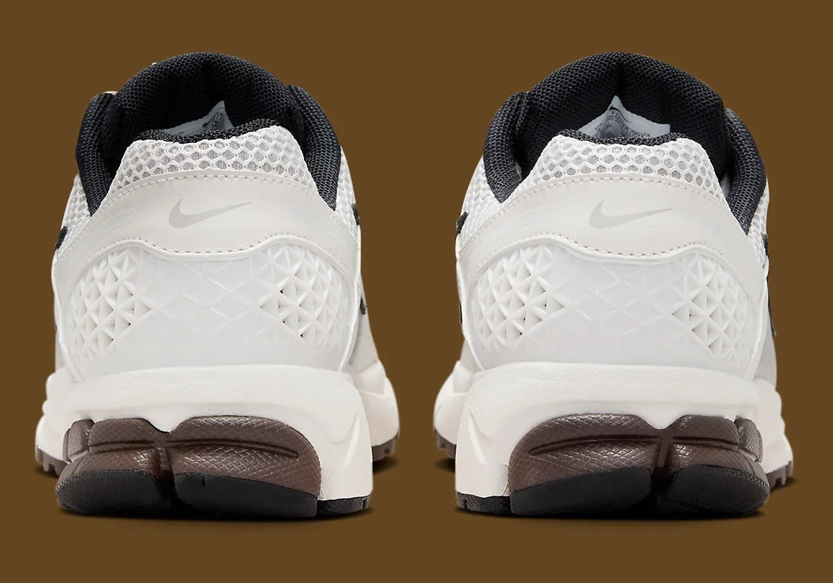 Image de la Nike Zoom Vomero 5 Phantom / Light Iron Ore, sneaker gris clair et blanc cassé en mesh et cuir, superpositions gris acier, semelle noire à amorti Zoom Air visible.