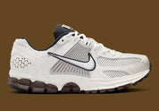 Image de la Nike Zoom Vomero 5 Phantom / Light Iron Ore, sneaker gris clair et blanc cassé en mesh et cuir, superpositions gris acier, semelle noire à amorti Zoom Air visible.