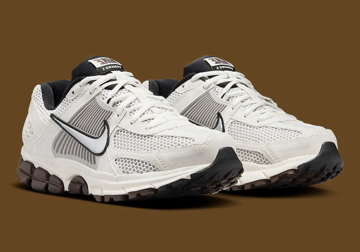  Light Iron Ore, sneaker gris clair et blanc cassé en mesh et cuir, superpositions gris acier, semelle noire à amorti Zoom Air visible.